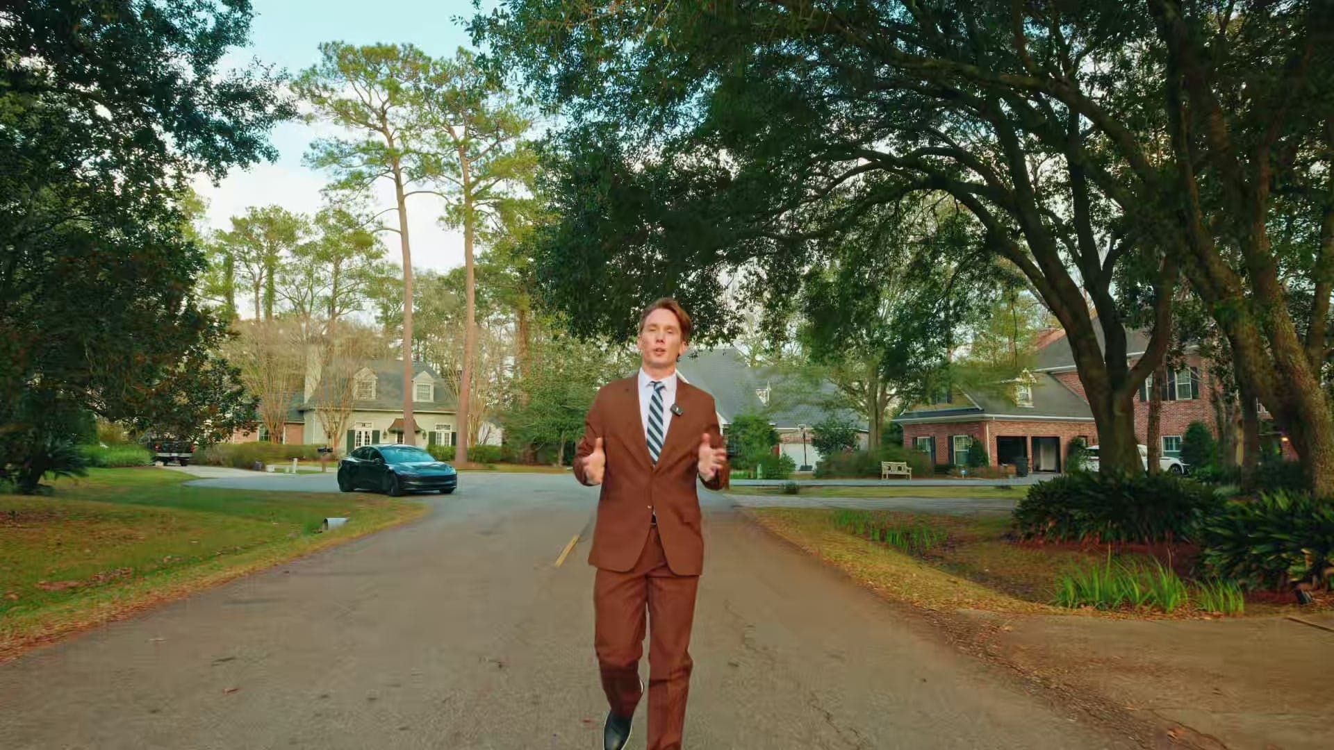 Garrett Shearman walking a tree-lined neighborhood street while presenting to camera